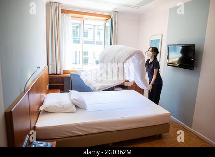 Hamburg, Deutschland. Mai 2021. Eine Frau macht das Bett in einem Hotelzimmer. Ab 01.06.2021 dürfen auch Hotels in Hamburg wieder Touristen empfangen, vorerst aber nur noch bei 60 Prozent ihrer Kapazität. Quelle: Daniel Reinhardt/dpa/Alamy Live News Stockfoto