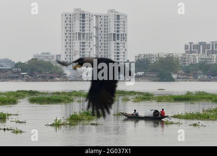 Kalkutta, Westbengalen, Indien. Mai 2021. Ein Boot schwimmt auf dem Fluss Ganga mit einem Hochhaus im Hintergrund in Kalkutta. Quelle: Indranil Aditya/ZUMA Wire/Alamy Live News Stockfoto