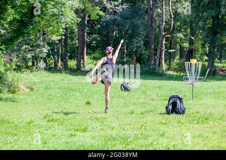 Junge Frau spielt fliegende Scheibe Sport-Spiel in der Natur Stockfoto