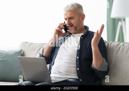 Wütend reifen Mann mit Telefon Kampf mit Internet-Anbieter Stockfoto
