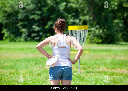 Junge Frau spielt fliegende Scheibe Sport-Spiel im Park Stockfoto