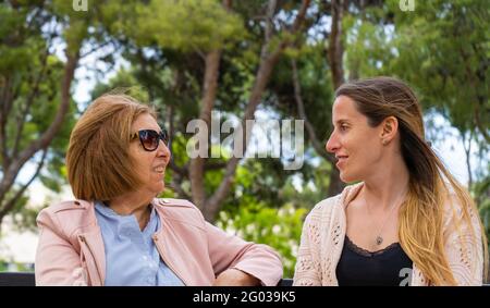 Glückliche ältere Mutter und ihre Erwachsene Tochter reden und Spaß im Park haben. Stockfoto