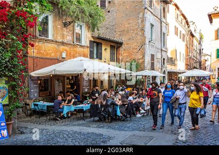 Im künstlerischen Touristenviertel sitzen Menschen vor einem Café Von Trastevere in Rom Stockfoto