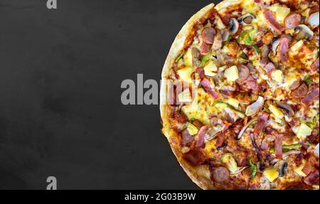 Pizza auf dem schwarzen Tafelhintergrund. Draufsicht Stockfoto