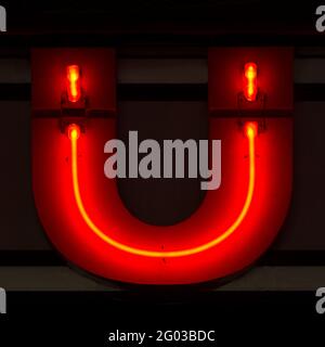 Rot glühender Neonbuchstabe Ü in der Nacht Stockfoto