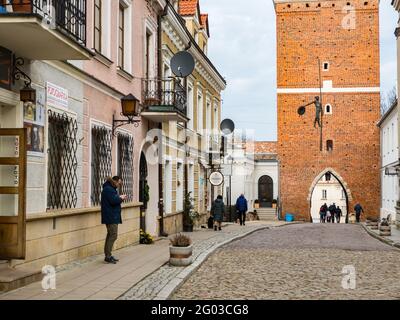 Sandomierz, Polen - 17. Februar 2020: Historische Mietshäuser und das prächtige Opatowska-Tor von Sandomierz, eines der ältesten und historisch Stockfoto