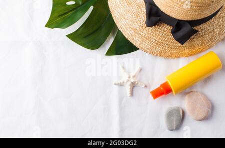 Summer background. Hat, seashells, sunscreen on a white towel. Copy space. Stockfoto