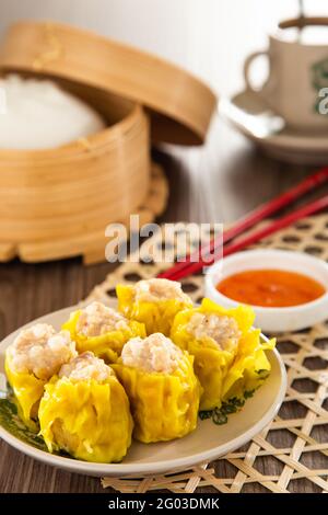 SIU Mai - Chinesische gedünstete Schweineknödel in Bambusdampfern. Stockfoto