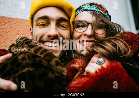 Porträt glücklicher männlicher und weiblicher Freunde, die sich umarmen Stockfoto