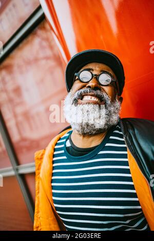 Fröhlicher bärtiger älterer Mann, der die Zähne zusammenklatscht Stockfoto