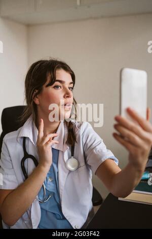 Ärztin, die den Patienten durch Videoanruf in der medizinischen Klinik konsultiert Stockfoto