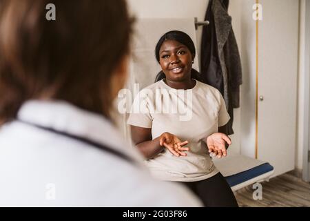 Junge Frau im Gespräch mit einer Ärztin in der medizinischen Klinik Stockfoto