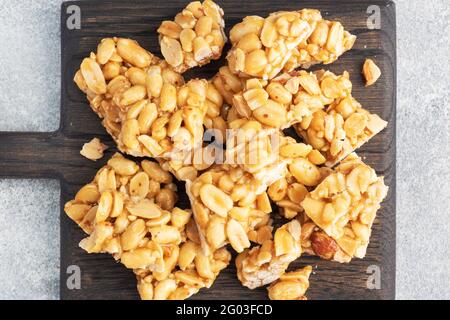 Erdnüsse in zuckerglasiert, orientalische Süße von brüchig. Kozinaks sind in Stücke auf einem Holzbrett gebrochen, kopieren Raum Draufsicht Stockfoto