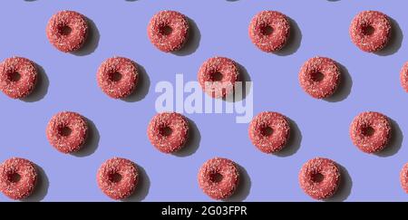 Rosa Donut Nahtloses Muster auf lila Hintergrund. Sonnenlicht minimal trendy Konzept. Draufsicht Stockfoto