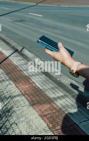 Frau, die auf der Straße auf das Smartphone schaut, als sie herkommt Der Park Stockfoto