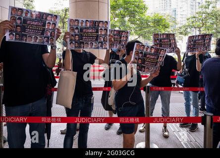 Hongkong, China. Mai 2021. Unterstützer halten Plakate von pro-demokratischen Persönlichkeiten vor Gericht, während sie sich in einer Schlange am West Kowloon Law Courts Building in Hongkong anstellen.47 pro-demokratische Aktivisten wurden nach dem nationalen Sicherheitsgesetz angeklagt, weil sie die Staatsmacht wegen ihrer Teilnahme an einer inoffiziellen Primary im Jahr 2020 zur Auswahl von pro-demokratischen Kandidaten unterbunden haben Für die seit dem Aufschub der Parlamentswahlen. Kredit: SOPA Images Limited/Alamy Live Nachrichten Stockfoto