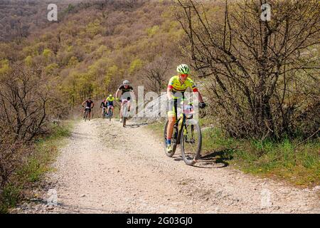 Jalta, Russland - 1. Mai 2021: Gruppenathleten Mountainbiker, die beim MTB-Rennen bergauf fahren Stockfoto