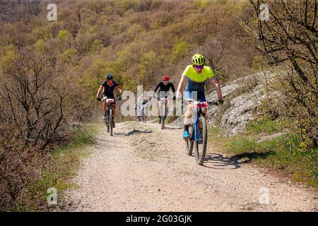 Jalta, Russland - 1. Mai 2021: Gruppenathleten Mountainbiker, die beim MTB-Rennen bergauf fahren Stockfoto