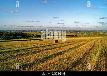 Großbritannien, South Yorkshire, Rotherham, Hay Bales in Feilen mit Blick auf die Stadt Wombwell und das Dorf Brampton Bierlow. Stockfoto