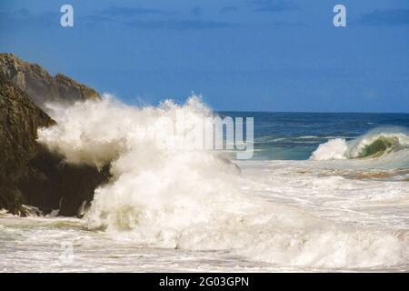 Große Wellen schlagen spektakulär gegen die steilen Klippen und zerklüfteten Küsten der südafrikanischen Tsitsikamma-Küste Stockfoto