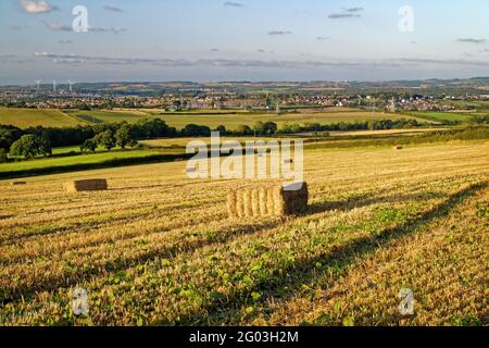 Großbritannien, South Yorkshire, Rotherham, Hay Bales in Feilen mit Blick auf die Stadt Wombwell und das Dorf Brampton Bierlow. Stockfoto