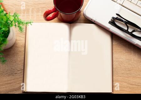 Draufsicht auf das geöffnete Buch mit leeren Blättern auf dem Schreibtisch Stockfoto