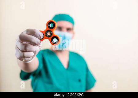 Ein Arzt in einer Maske und Handschuhen, mit einem Spinner in den Händen. Hochwertige Fotos Stockfoto