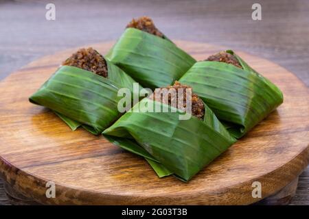 Kuih Pulut inti, traditionelles malaysisches Dessert. Pikanter Klebreis mit gesüßter geriebener Kokosnuss, eingewickelt in Bananenblatt Stockfoto