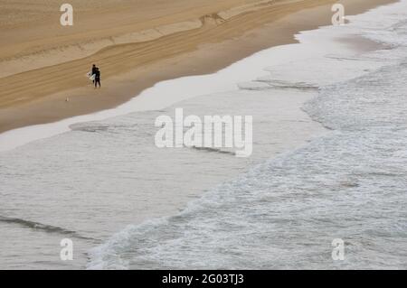 Ein paar Surfer gehen mit ihren Surfbrettern auf dem Strand am Bondi Beach Stockfoto