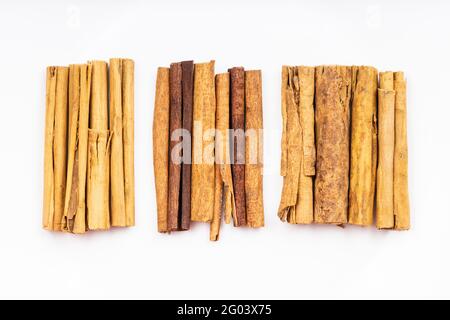 Draufsicht auf verschiedene Zimtschnecken (Alba Premium ceylon, chinesischer Cassia und kontinentaler ceylon-Zimt) auf weißem Teller Stockfoto