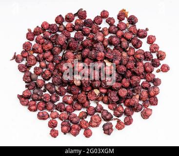 Draufsicht auf den Haufen getrockneter Magnolienbeeren (Schisandra chinensis Fruits) Nahaufnahme auf grauer Keramikplatte Stockfoto