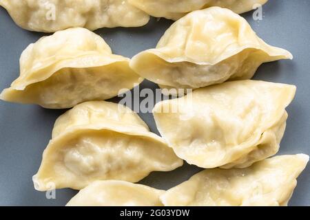 Draufsicht auf gekochte Knödel auf grauem Teller aus nächster Nähe Stockfoto