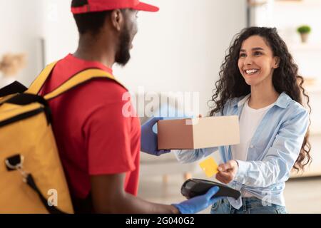 Porträt eines schwarzen Mannes, der die Kasse für die Zahlung hält Stockfoto