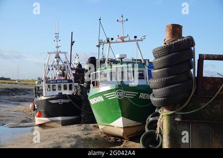 LEIGH-ON-SEA, VEREINIGTES KÖNIGREICH - Dec 20, 2020: Zwei Cockle-Boote, die in der britischen Fischereiindustrie eingesetzt wurden, vertäuten bei Ebbe in der Themse-Mündung bei Leigh-o Stockfoto