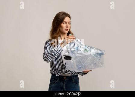 Junge Schöne Frau Putting Plastikflaschen Zu Container In Sie Hände Stockfoto