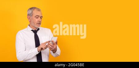 Isolierter älterer Erwachsener mit Mobiltelefon Stockfoto