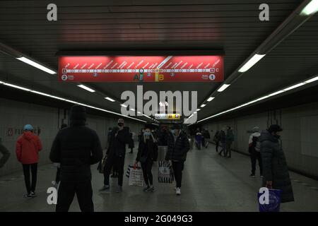 PRAHA, TSCHECHISCHE REPUBLIK - 11. Dezember 2020: Menschen in Masken auf einer Plattform, wechseln von der B- auf die C-Linie der Prager U-Bahn, mit Blick auf das Informationstafel. Stockfoto