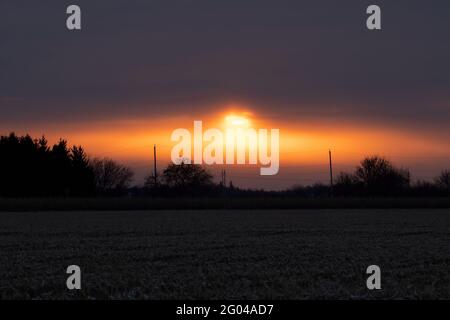 Dramatischer Sonnenaufgang auf dem Land. Kalter Wintermorgen in Kanada. Stockfoto