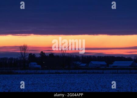 Farbenprächtiger Sonnenaufgang auf dem Land im Winter Stockfoto