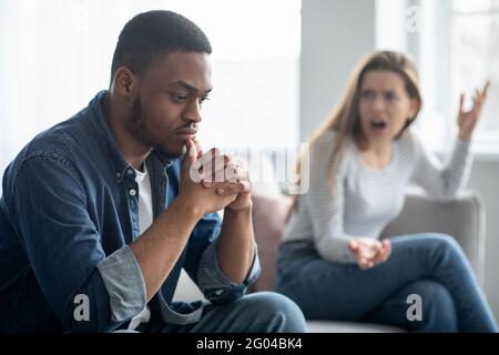 Beziehungskrise. Junge Interracial Paar Streiten Im Wohnzimmer Zu Hause Stockfoto