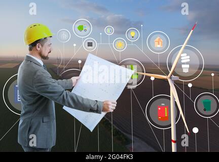 Ingenieur mit Zeichnung auf Windmühlenpark für die Stromproduktion Stockfoto