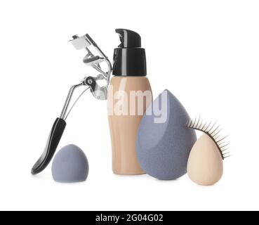 Make-up Schwämme mit einer Flasche tonaler Foundation und Wimpern-Lockenstab Auf weißem Hintergrund Stockfoto