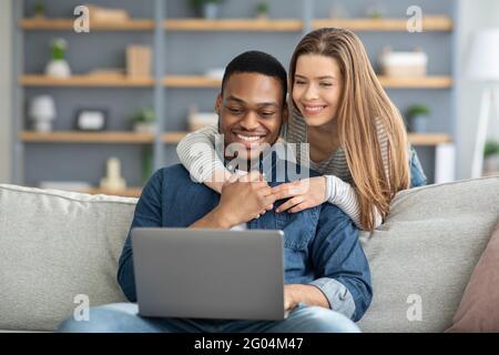 Portrait Von Happy Happy Young Multikulturelle Ehepartner Mit Laptop Bei Zu Hause Stockfoto