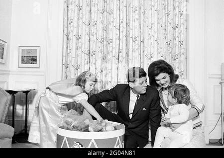 Präsident John F. Kennedy und First Lady Jacqueline Kennedy besuchen mit ihren Kindern Caroline Kennedy und John F. Kennedy, Jr., nach einer gemeinsamen Geburtstagsfeier für die Kinder in Johns Kinderzimmer. White House, Washington, D.C. Stockfoto