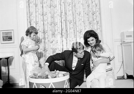 Präsident John F. Kennedy und First Lady Jacqueline Kennedy besuchen mit ihren Kindern Caroline Kennedy und John F. Kennedy, Jr., nach einer gemeinsamen Geburtstagsfeier für die Kinder in Johns Kinderzimmer. White House, Washington, D.C. Stockfoto