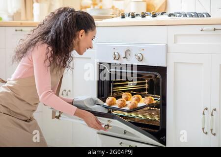 Kochen Zu Hause. Schöne Brünette Lady Backen In Der Küche, Tray Out Ofen Stockfoto