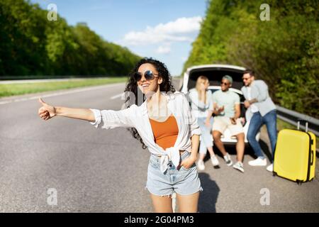 Junge Dame, die mit ihren Freunden unterwegs war, das Auto anhielt, auf der Autobahn anhielt und Hilfe bei einem kaputten Fahrzeug brauchte Stockfoto