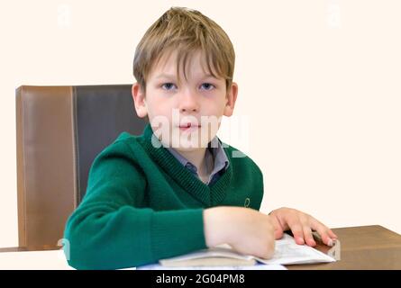 7 Jahre Schuljunge, der seine Schulaufgaben macht Stockfoto