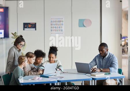 Weitwinkelansicht von Schülern und Lehrern, die zusammen an arbeiten Modernes Klassenzimmer Stockfoto