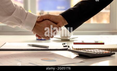 Die Geschäftsleute beendeten das Treffen und den Händedruck des glücklichen Geschäftsmannes, nachdem der Vertrag geschlossen wurde, um gemeinsam ein Teamwork-Partner zu sein. Stockfoto